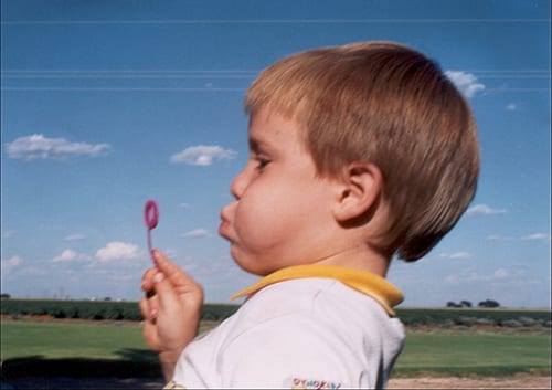 child blowing bubbles