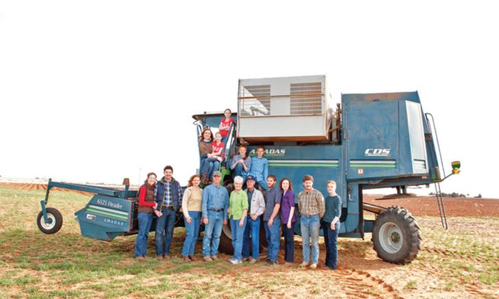 Eddie and Peggy Bingham, Cliff and Betty Bingham, and their children in front of a peanut combine at Bingham Organic Farm.